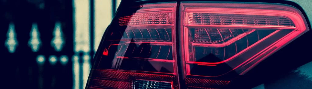 Close-up of modern car tail lights illuminated in red