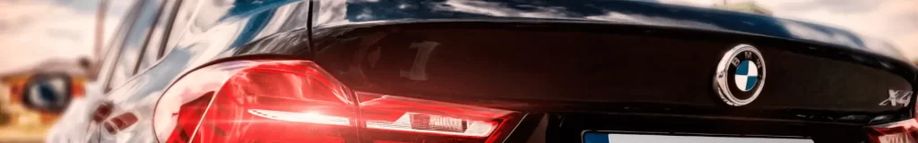 Close-up of modern car tail lights illuminated in red with a dark background